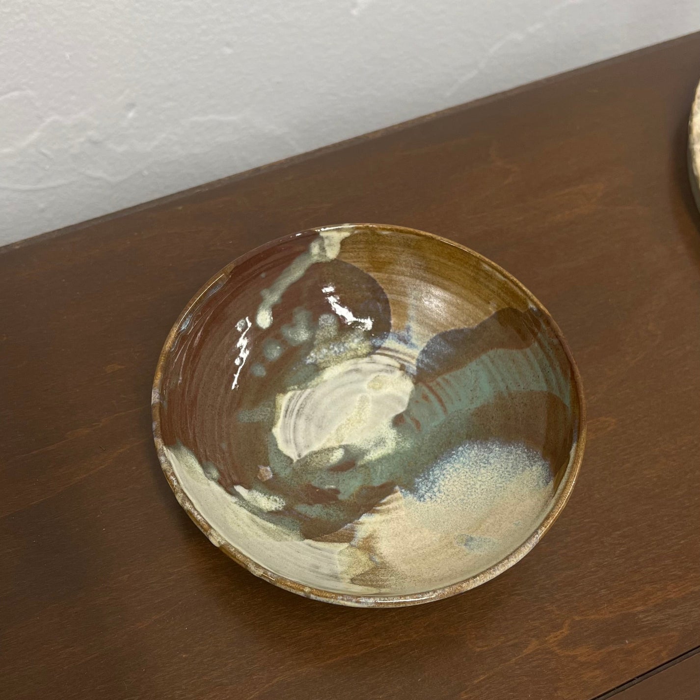 Ceramic bowl with a unique glaze pattern on a wooden surface